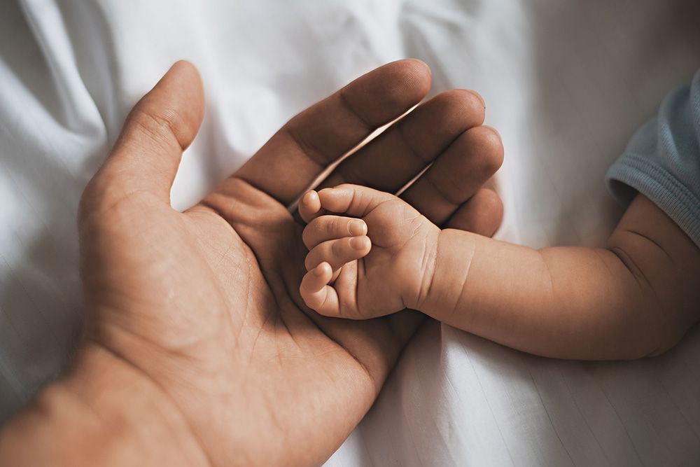 Baby resting hand in adult hand